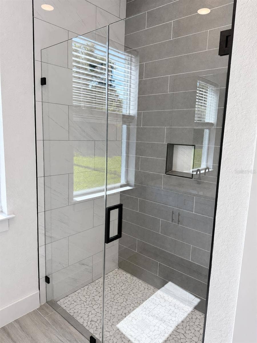 24479 SW KINGSWAY CIRCLE, Arcadia, FL 34269 Primary glass shower. Actual property photo, digitally refined.