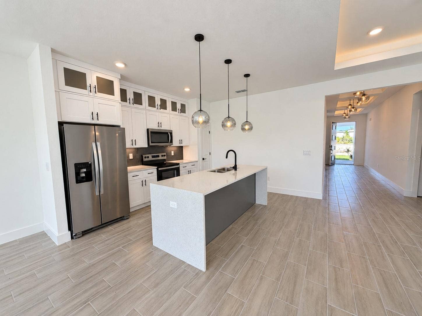 24479 SW KINGSWAY CIRCLE, Arcadia, FL 34269 Kitchen toward entry. Actual property photo, digitally refined.