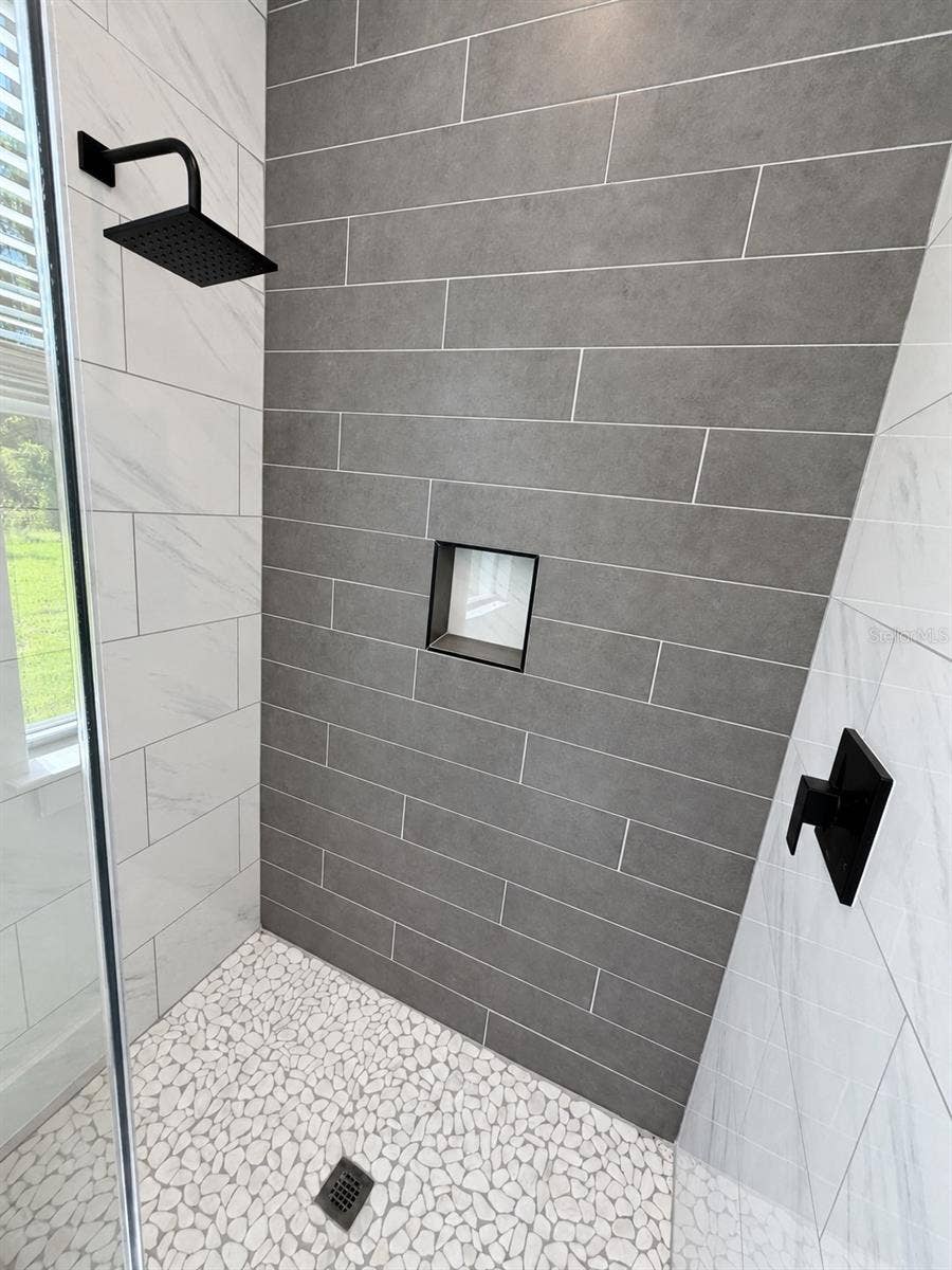 24479 SW KINGSWAY CIRCLE, Arcadia, FL 34269 Primary shower tile detail. Actual property photo, digitally refined.