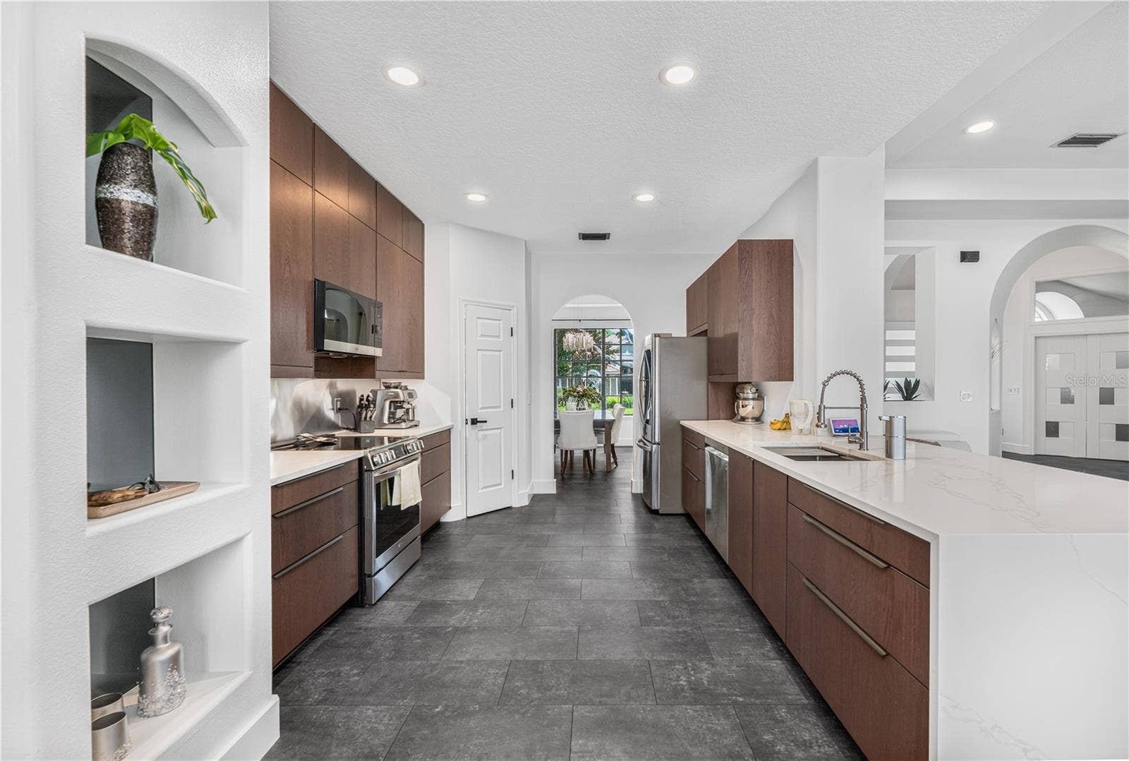 1854 VISTA ROYALE BOULEVARD, Orlando, FL 32835 Modern kitchen featuring beautiful cabinetry, waterfall quartz counters, and stainless steel appliances.