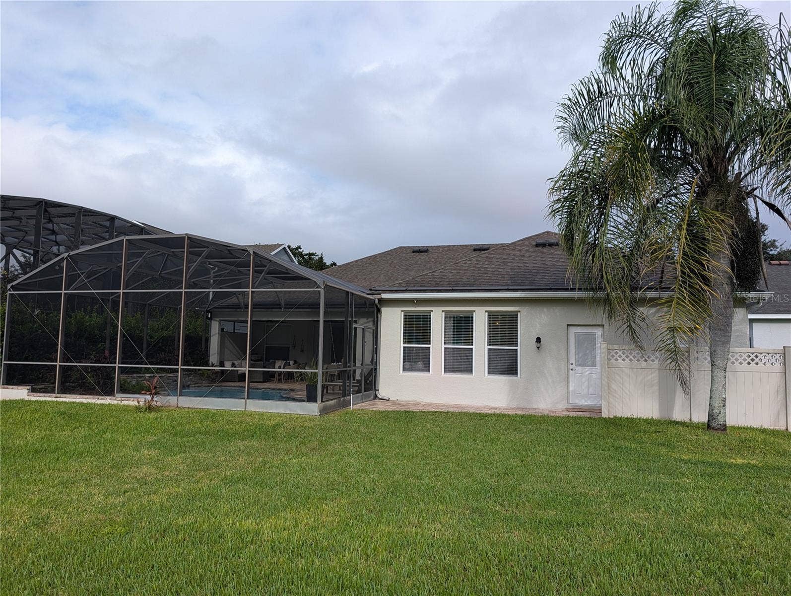 back ard with screened in lanai & pool