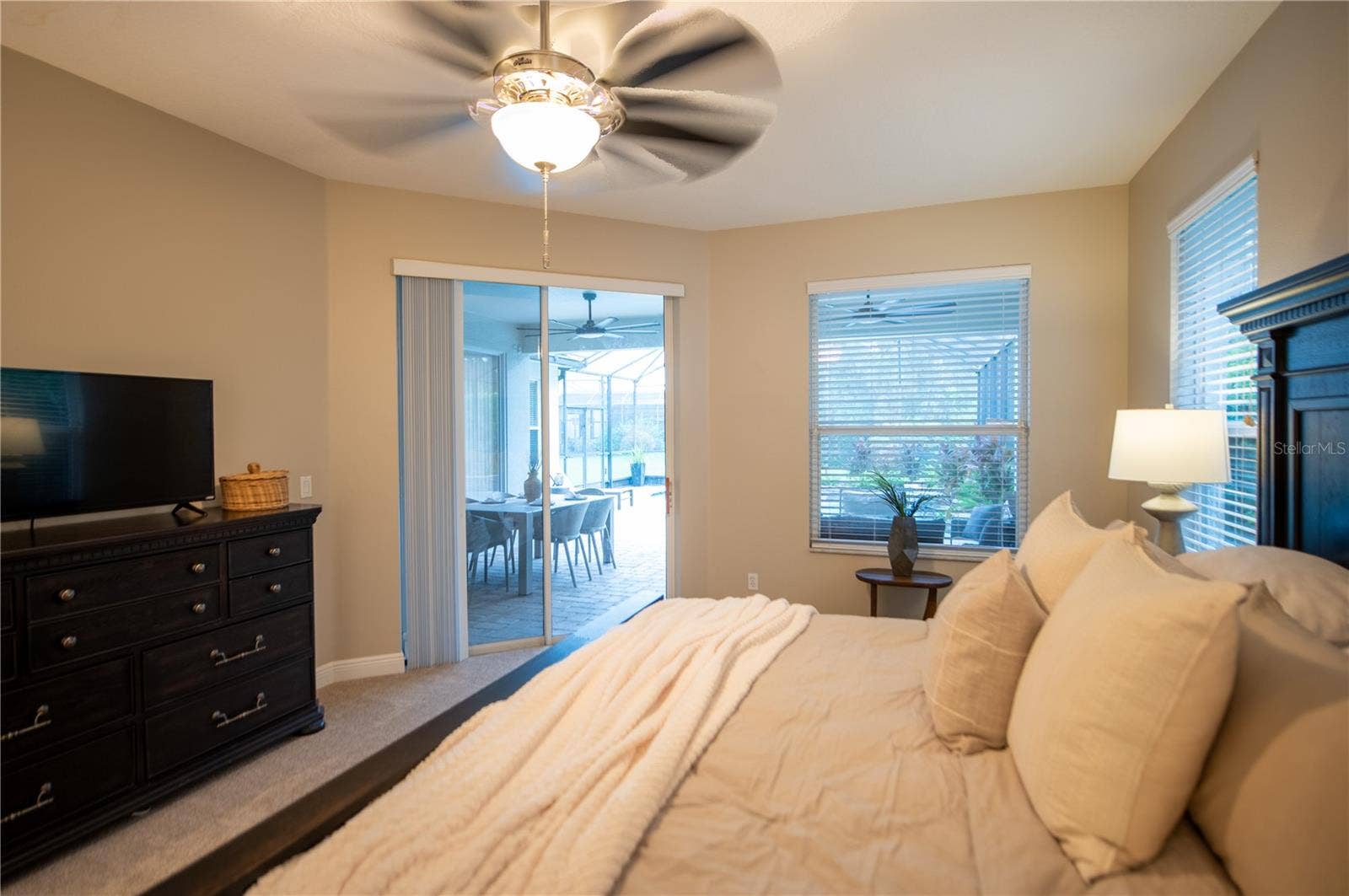 primary bedroom with door to lanai & pool