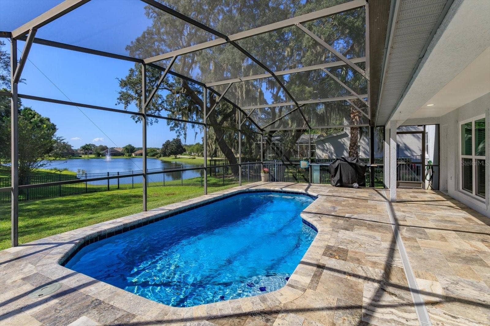 6887 HIDDEN GLADE PLACE, Sanford, FL 32771 Freshly sealed Travertine pavers surround the screen enclosed pool