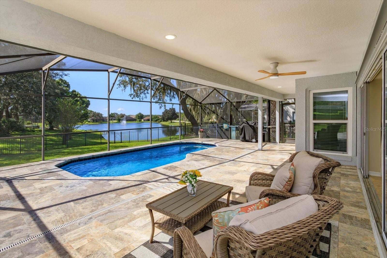 6887 HIDDEN GLADE PLACE, Sanford, FL 32771 Travertine pavers on the covered porch and pool with sunset and water views