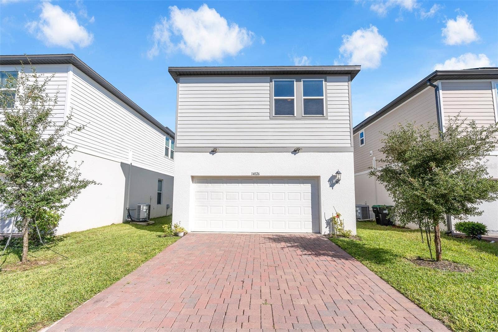 14026 FRASIER STREET, Winter Garden, FL 34787 Rear exterior with two-car garage and paver driveway.