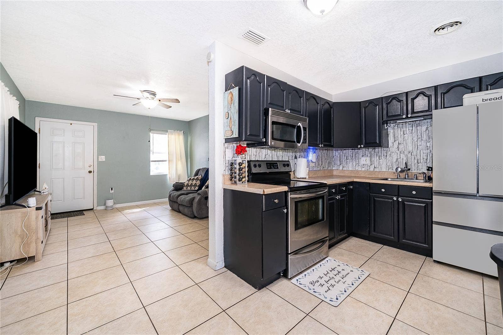 800 DORADO AVENUE, Orlando, FL 32807 Enjoy preparing meals in this functional kitchen featuring dark cabinetry, ample countertop space, and easy access to the dining area.