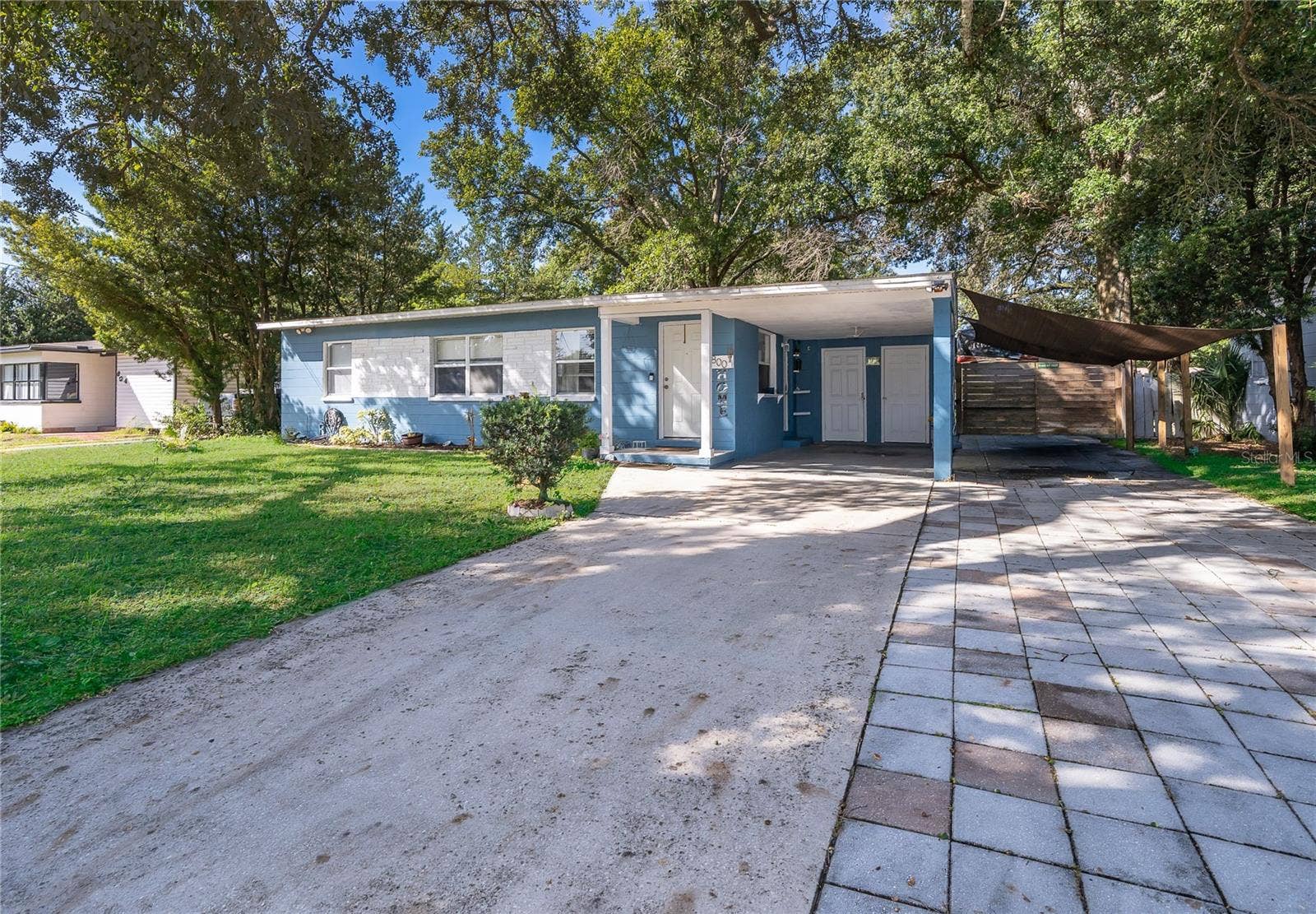 800 DORADO AVENUE, Orlando, FL 32807 A welcoming driveway leads you to this charming home, surrounded by established landscaping and beautiful greenery.