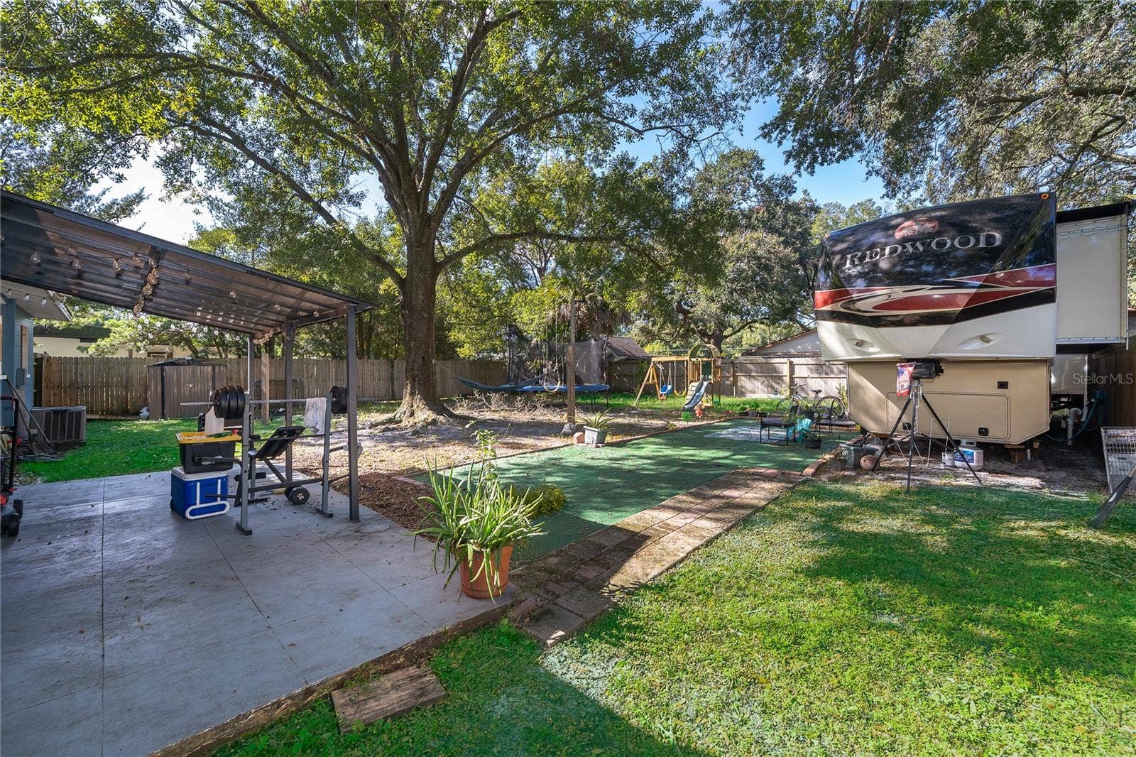 800 DORADO AVENUE, Orlando, FL 32807 Step outside and discover a spacious backyard with mature trees, a patio area, and plenty of room to enjoy the outdoors.