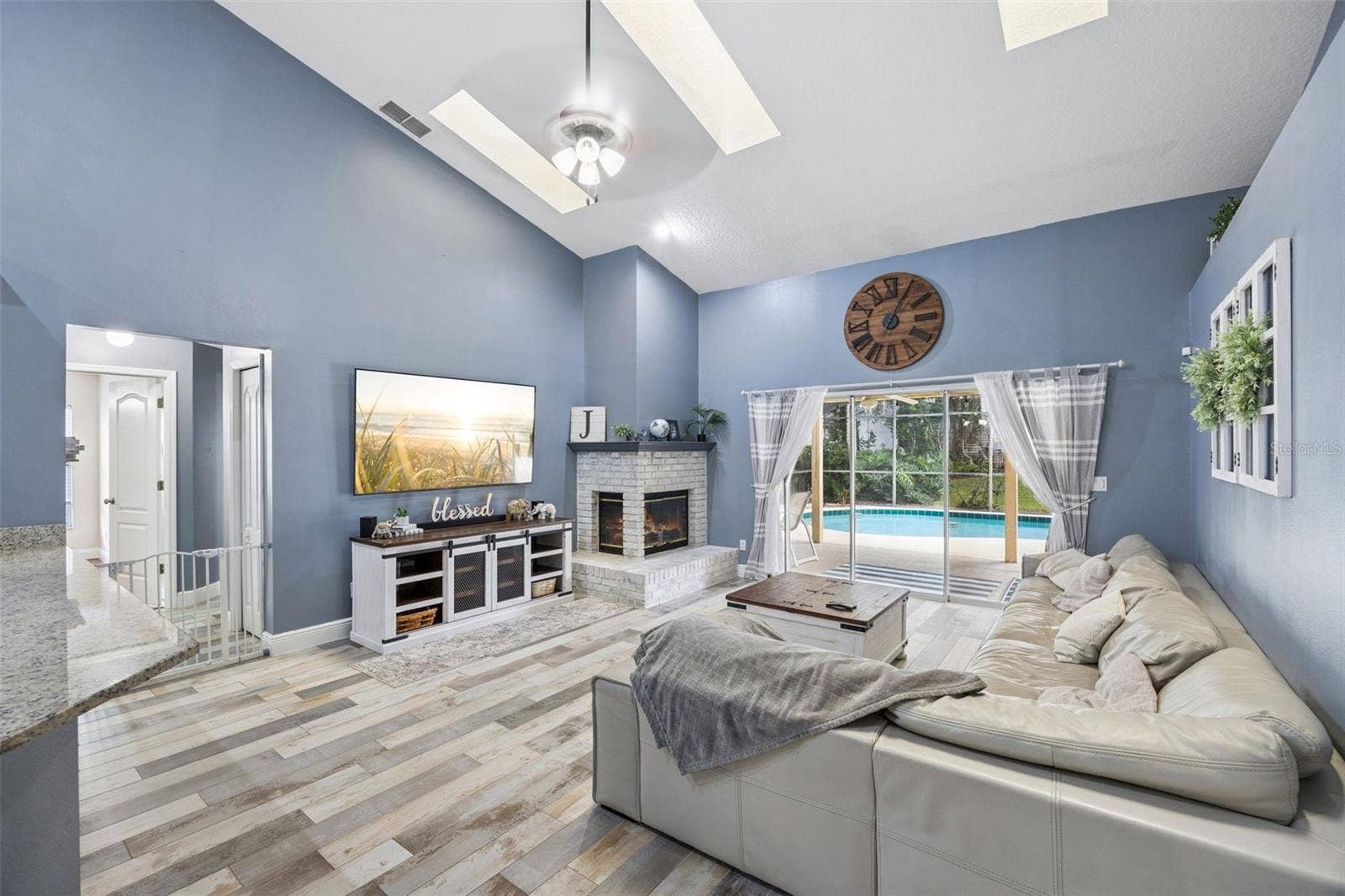 1505 Grassy Ridge Ln- Family room with vaulted ceiling, fireplace, and pool view