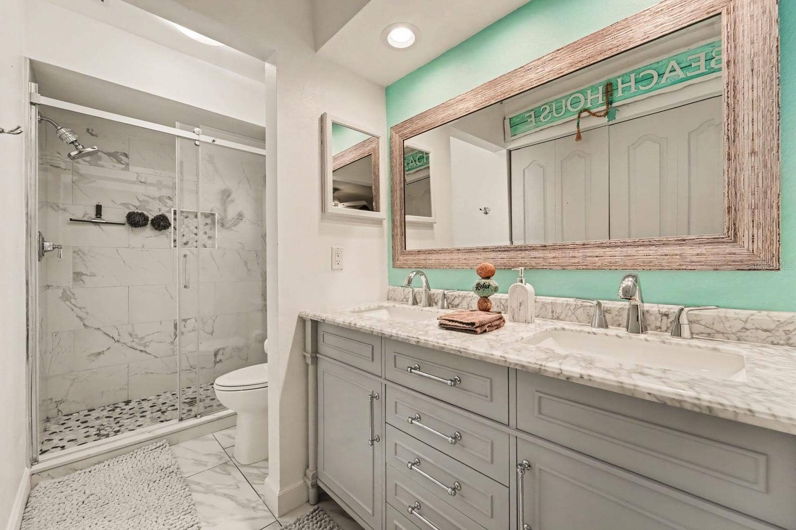 143 CROWN POINT CIRCLE, #143, Longwood, FL 32779 Primary bath features walk-in shower with marble tile, frameless glass enclosure