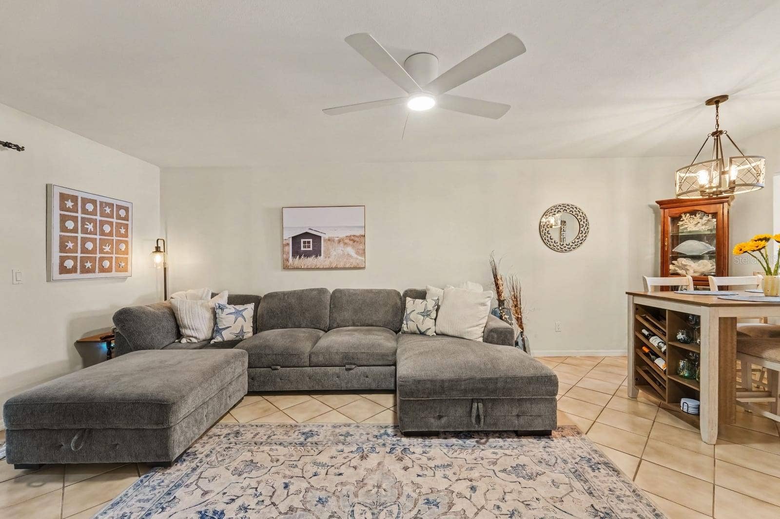 143 CROWN POINT CIRCLE, #143, Longwood, FL 32779 Open Living Room with Gray Sectional, Ceiling Fan, and Decorative Accents