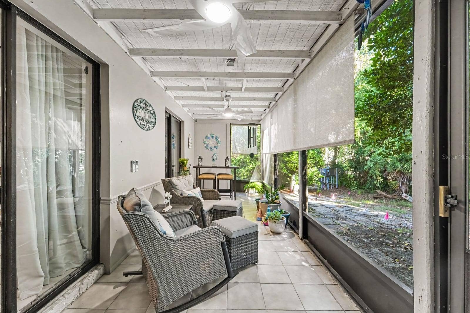 143 CROWN POINT CIRCLE, #143, Longwood, FL 32779 Screened Patio with Wicker Seating Overlooking Lush Landscaping