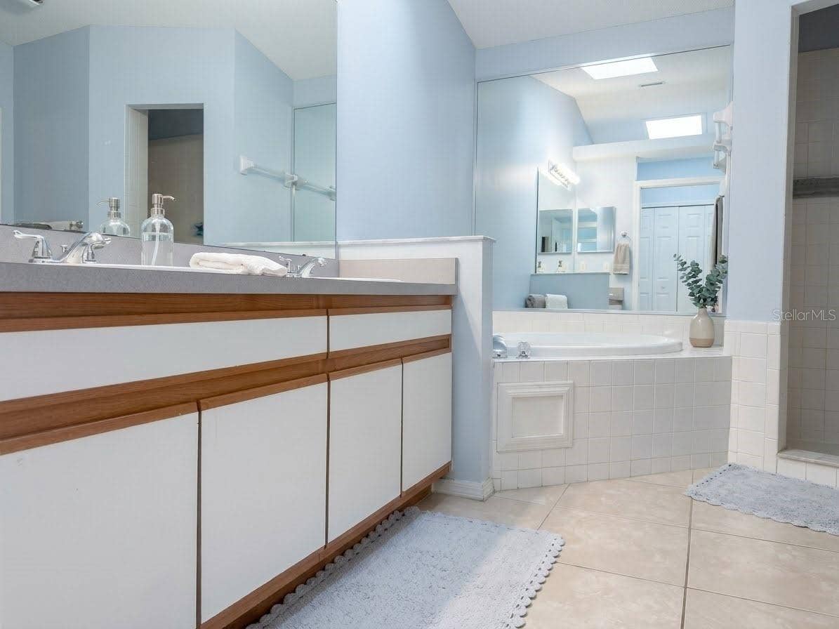 989 HAMLET COURT, Maitland, FL 32751 En-suite primary bathroom features ceramic tile, garden tub, and shower.