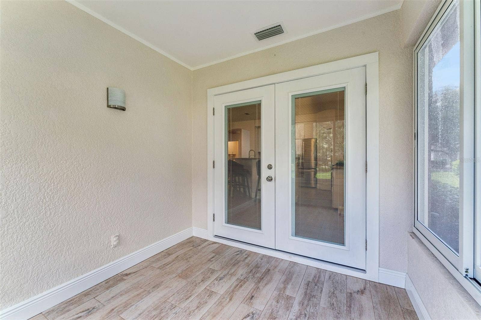 Enclosed Lanai w/ double pane French doors that lead into the home