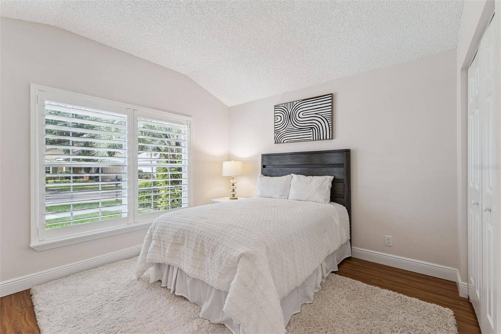 12' x 10'6" Bedroom #2 w/ laminate floor & Plantation style shutters