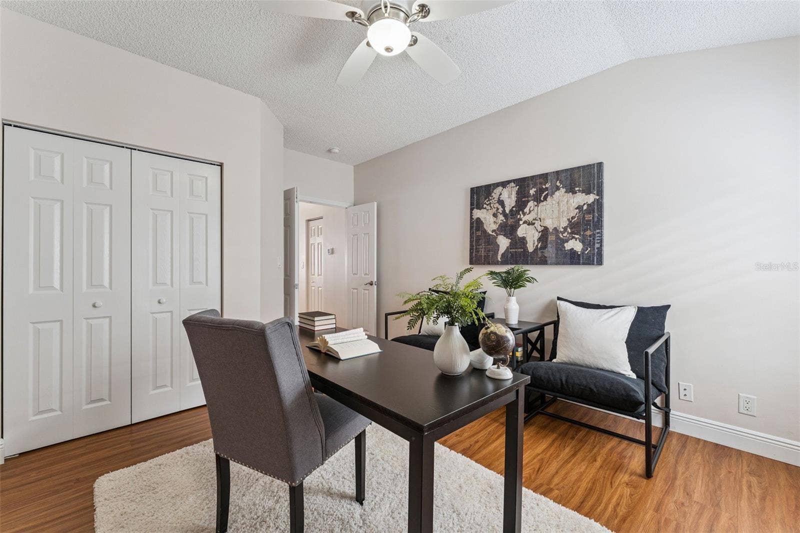 Bedroom #3 w/ a laminate floor, double door entry & a ceiling fan