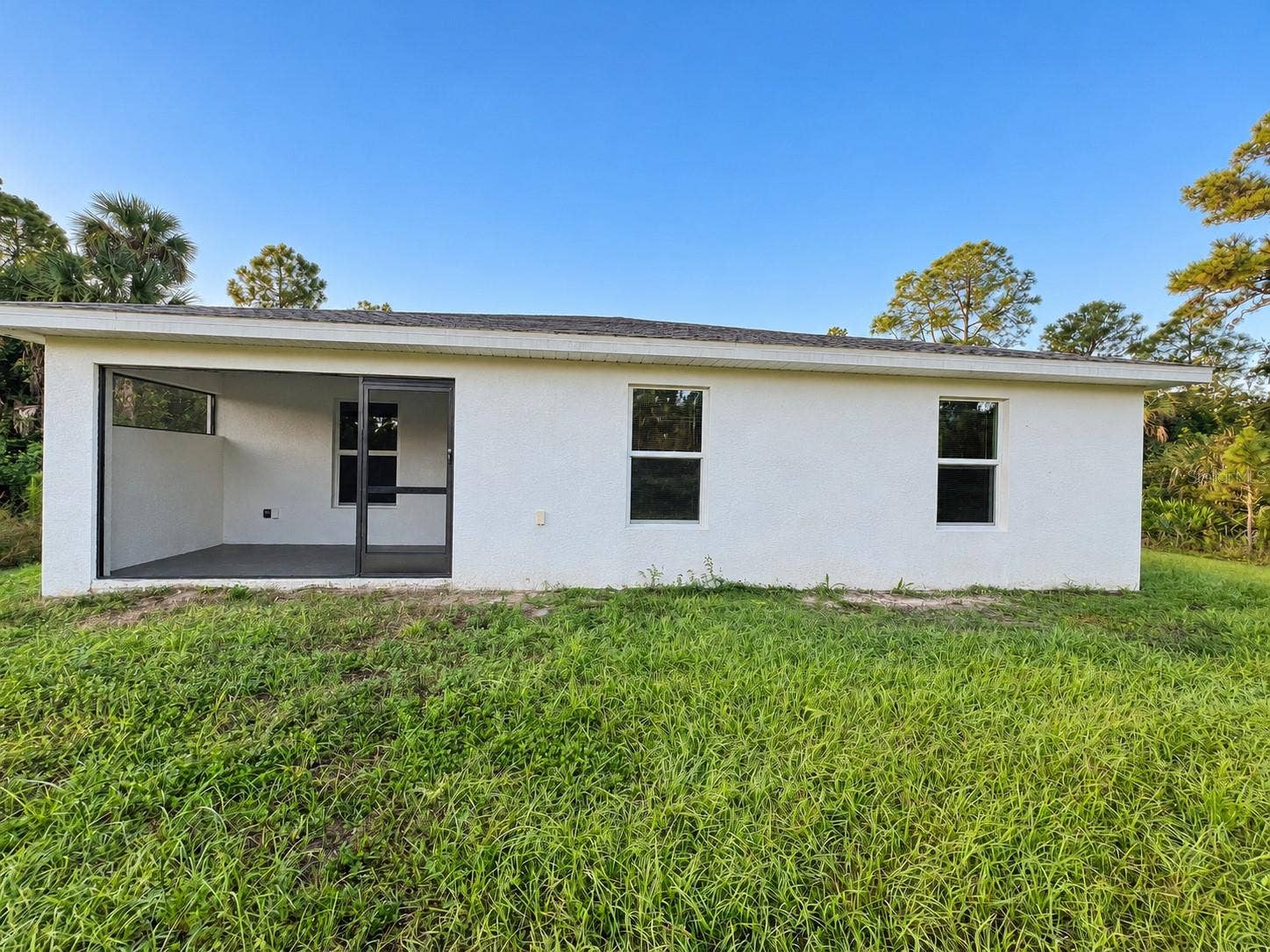 3404 61ST STREET W, Lehigh Acres, FL 33971 Rear exterior digitally enhanced; original patio paint color retained.
