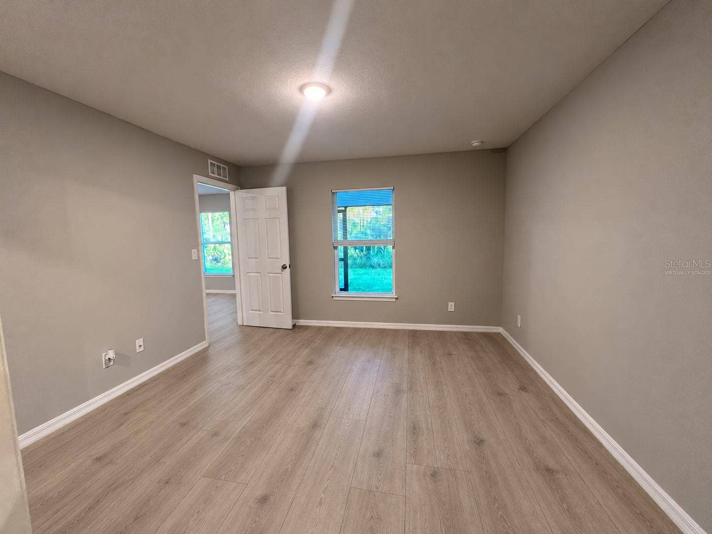 3404 61ST STREET W, Lehigh Acres, FL 33971 Primary bedroom reverse angle virtually staged: planned laminate flooring.