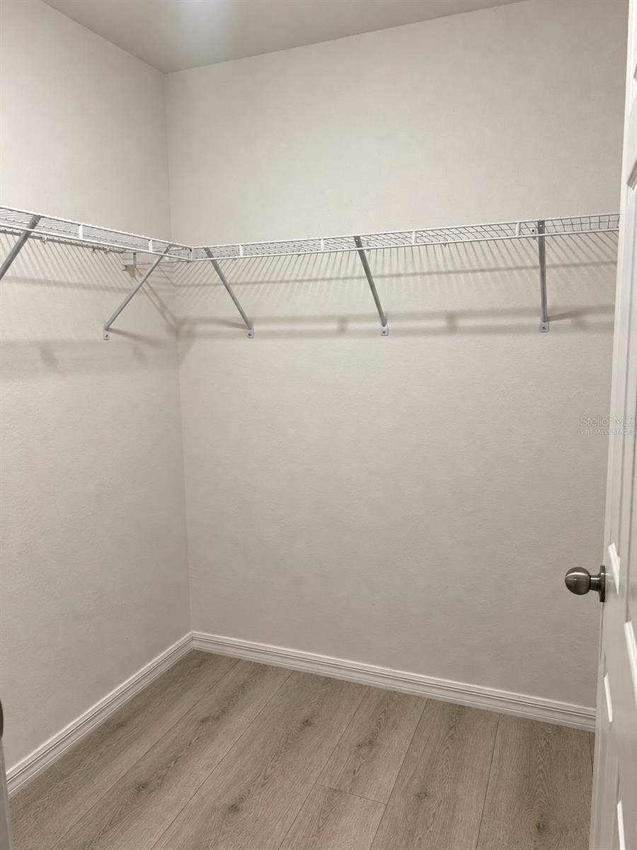 3404 61ST STREET W, Lehigh Acres, FL 33971 Walk-in closet virtually staged: planned laminate flooring.