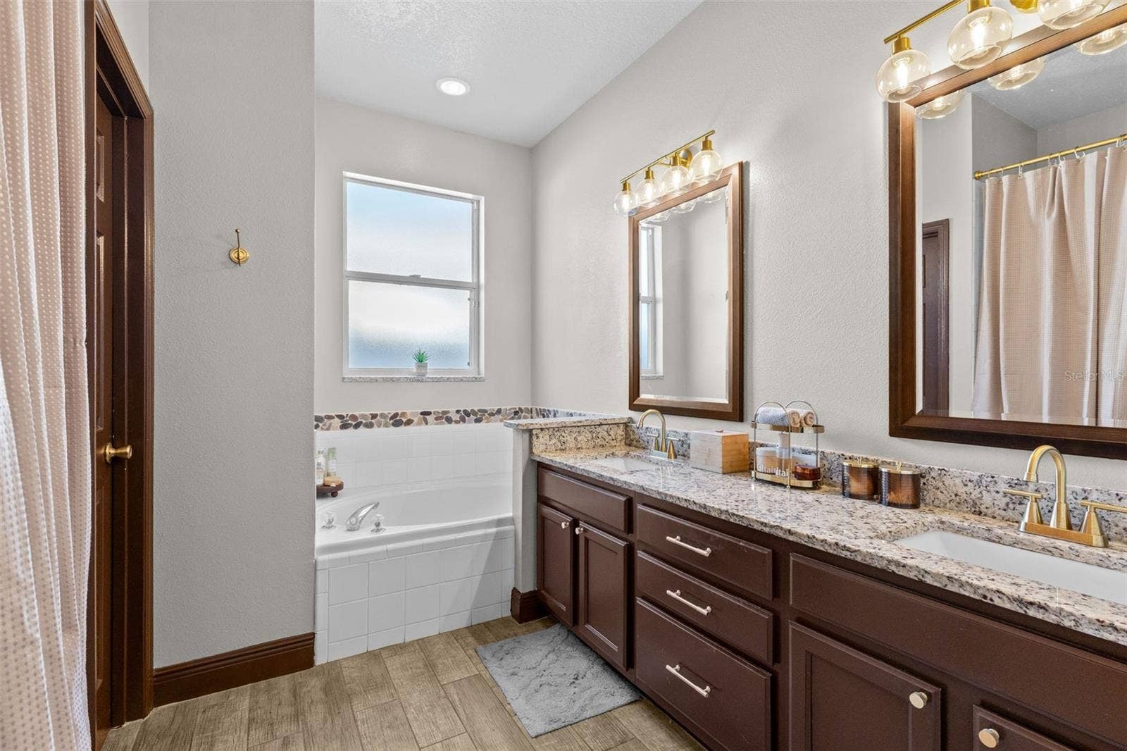 10337 ANDOVER POINT CIRCLE, Orlando, FL 32825 Primary bathroom with double vanity, soaking tub, walk-shower and toilet closet.