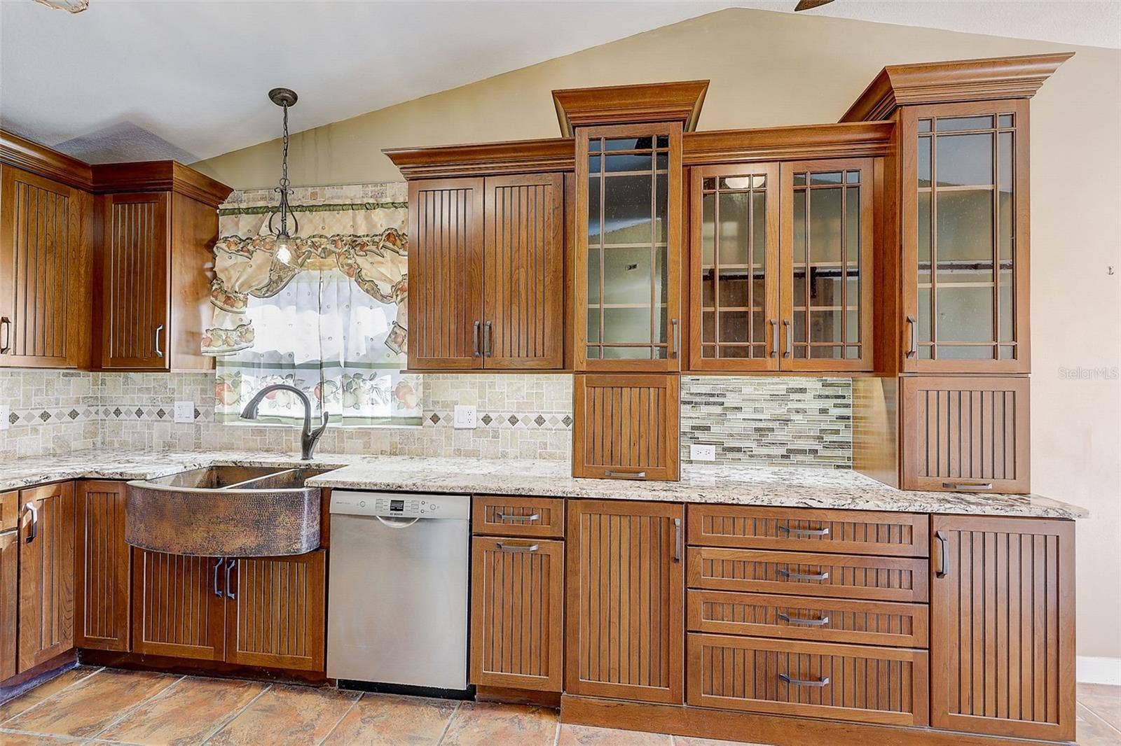 The custom-renovated kitchen, completed in 2021, is a standout feature, offering custom cabinetry with soft-close doors and drawers, polished granite countertops with natural edges, a custom tile backsplash, a copper undermount sink, and a touch-operated faucet with an integrated pot-filler feature. Additional details include a solid-wood barn door pantry, a built-in cabinet with antique glass doors and interior lighting, under-cabinet lighting, and quality appliances, including a French-door refrigerator, extra-quiet Bosch dishwasher, microwave installed in the lower cabinetry, and LG double oven, complemented by a full-size copper overhead range exhaust hood.