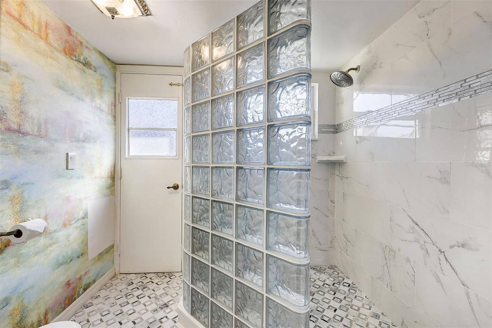 **The primary bedroom and bathroom have been pained since these pictures** The downstairs primary suite offers a private, walled courtyard, direct access to the pool deck, and custom closet shelving installed in 2025. The primary bathroom, renovated in 2020, features a custom-tiled walk-in shower, rain-style showerhead, glass-block divider, and a high-set triple-pane window.