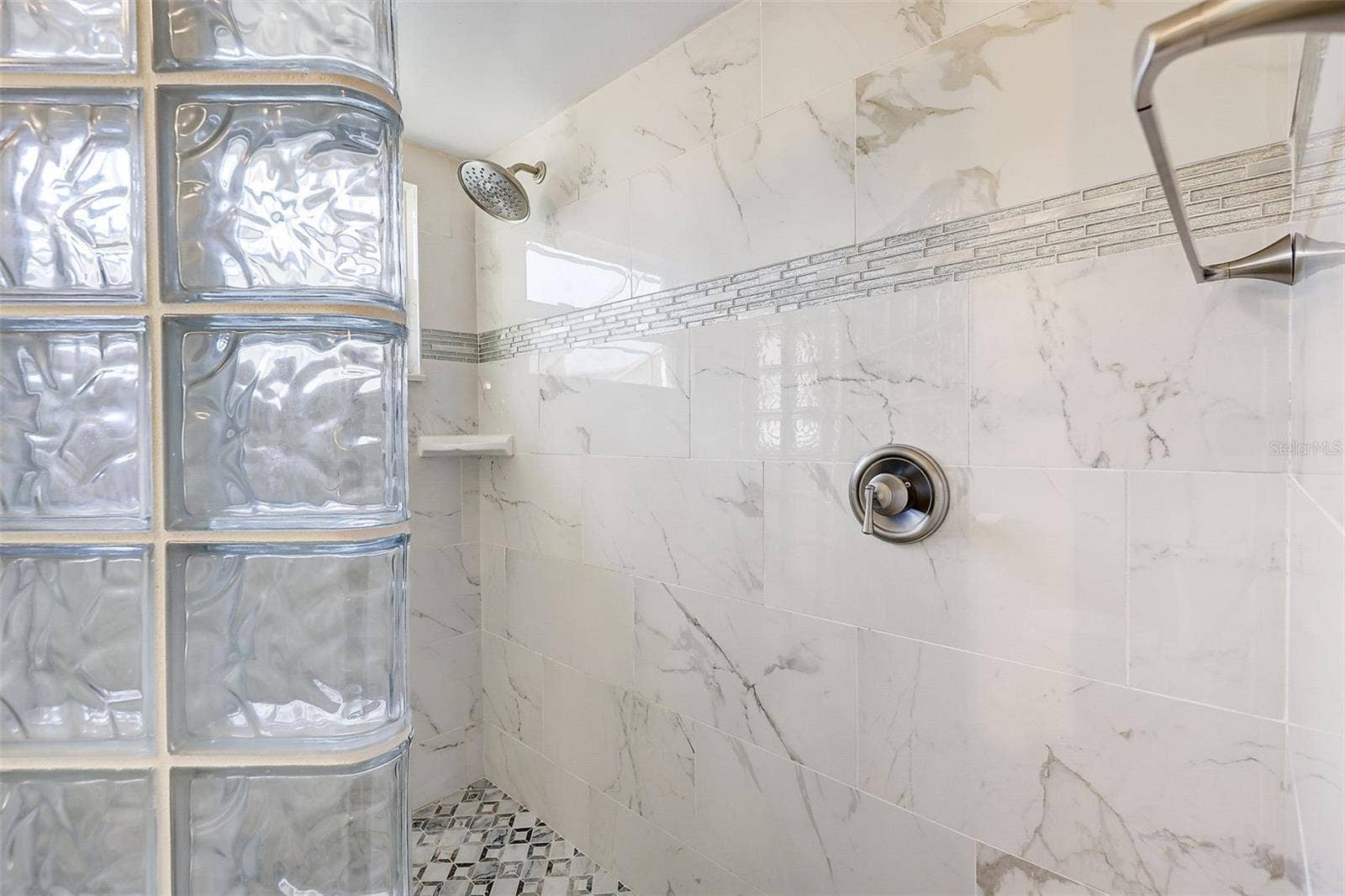 **The primary bedroom and bathroom have been pained since these pictures** The downstairs primary suite offers a private, walled courtyard, direct access to the pool deck, and custom closet shelving installed in 2025. The primary bathroom, renovated in 2020, features a custom-tiled walk-in shower, rain-style showerhead, glass-block divider, and a high-set triple-pane window.