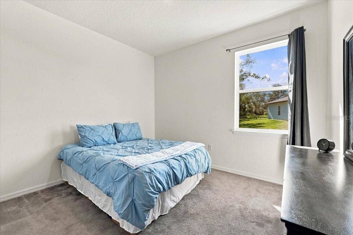 Bright and inviting secondary bedroom featuring natural light, comfortable living space, and a versatile layout.
