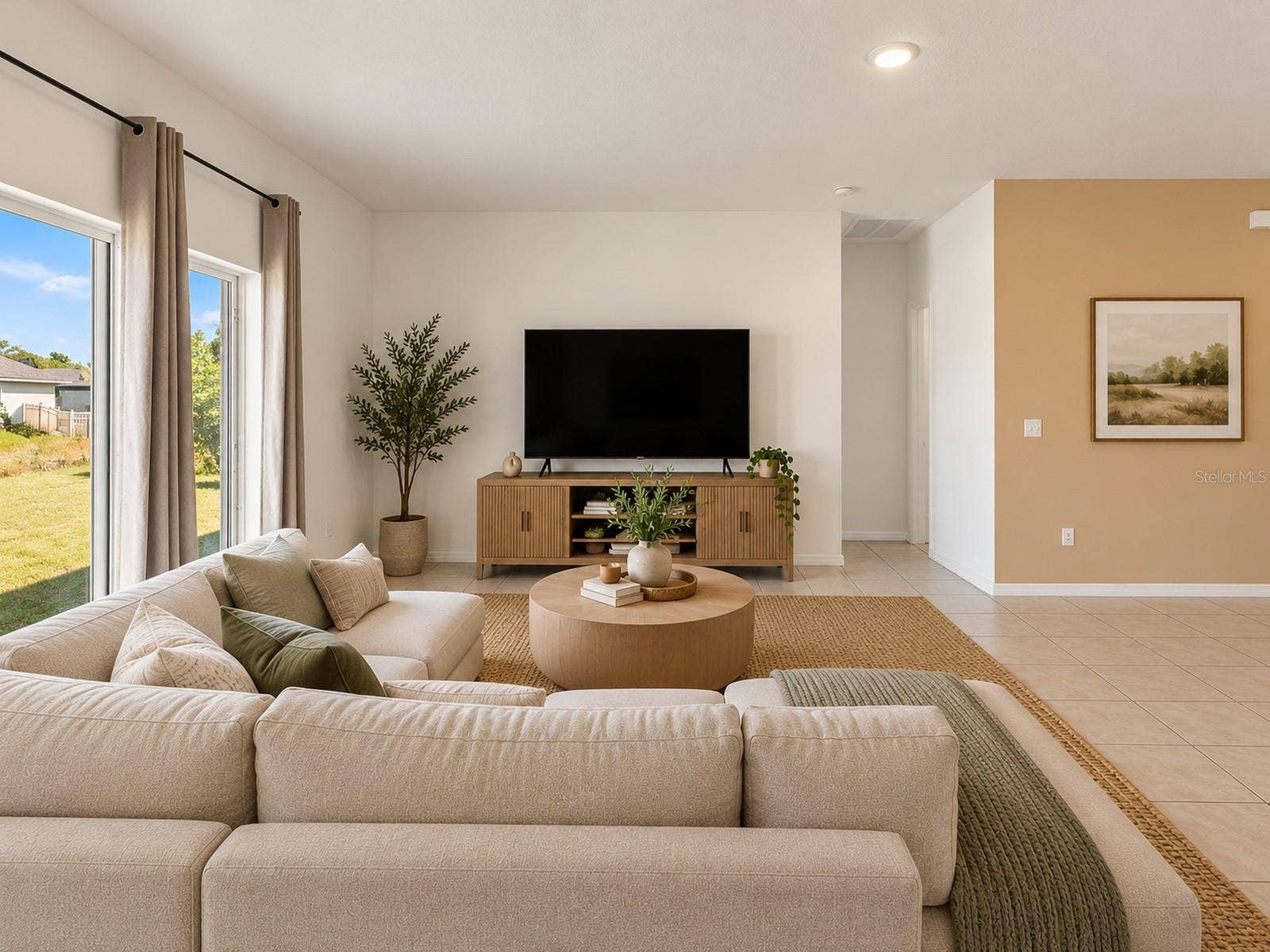 Digitally staged living room showcasing a spacious layout, abundant natural light, and sliding glass door access to the backyard.