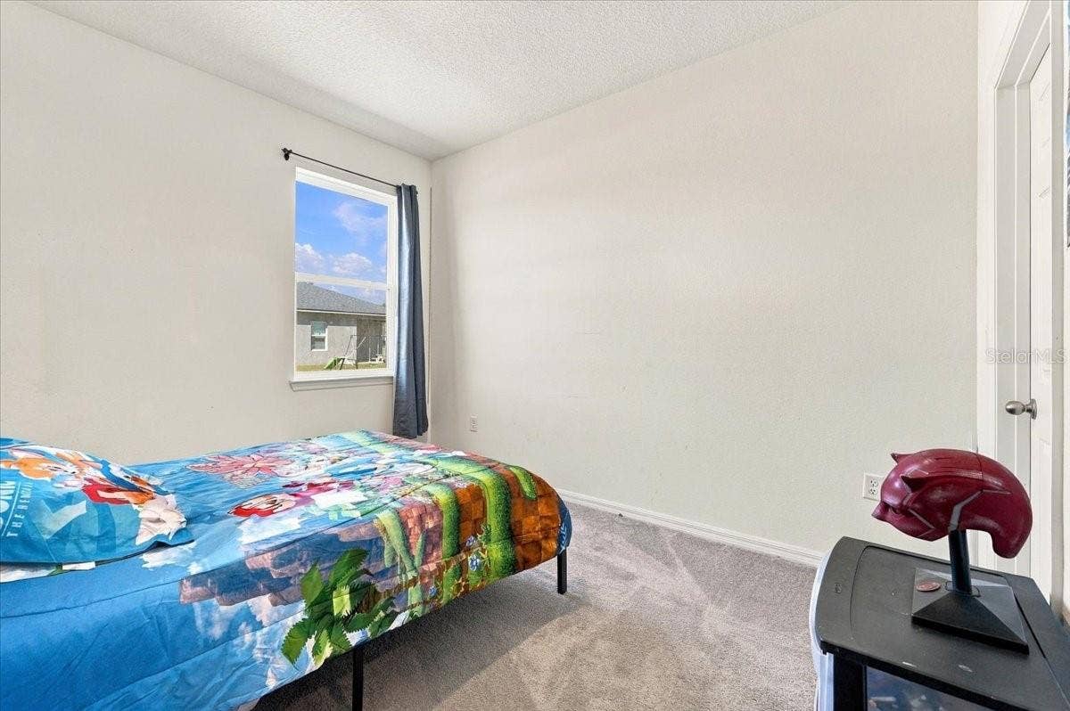 Comfortable secondary bedroom with natural light and a walk-in closet offering additional storage space.
