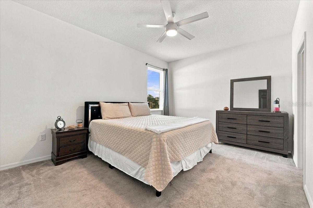 Spacious primary bedroom with room for a king-size bed and additional bedroom furniture.