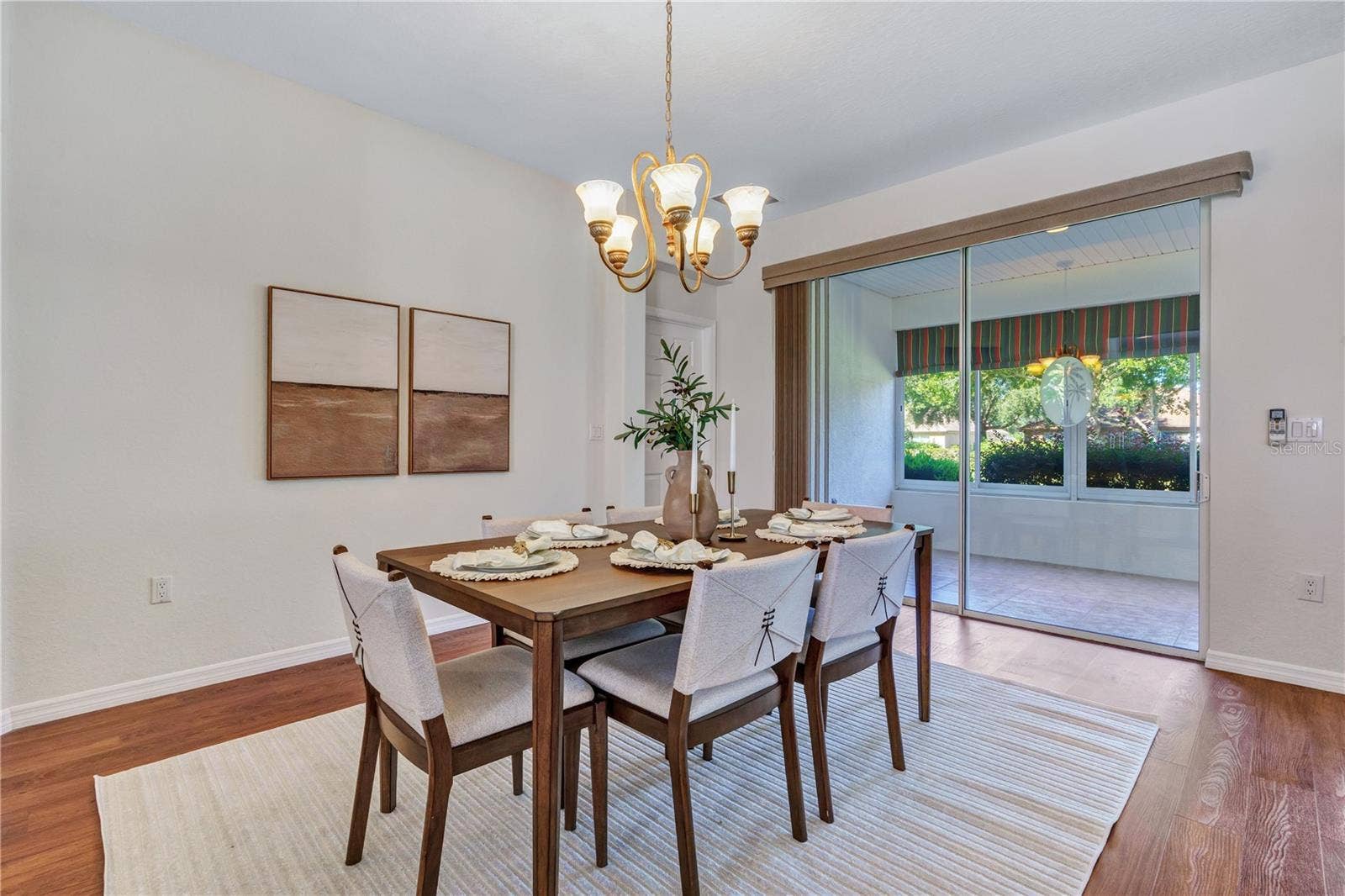 Dedicated dining area with elegant lighting and convenient access to the enclosed lanai