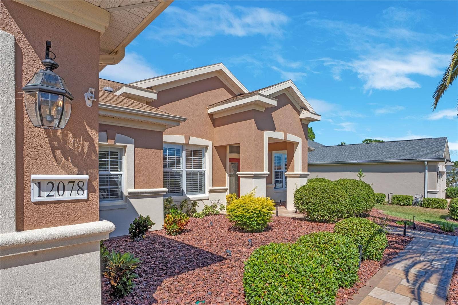 Welcoming entry with attractive architectural details and low-maintenance Florida landscaping.