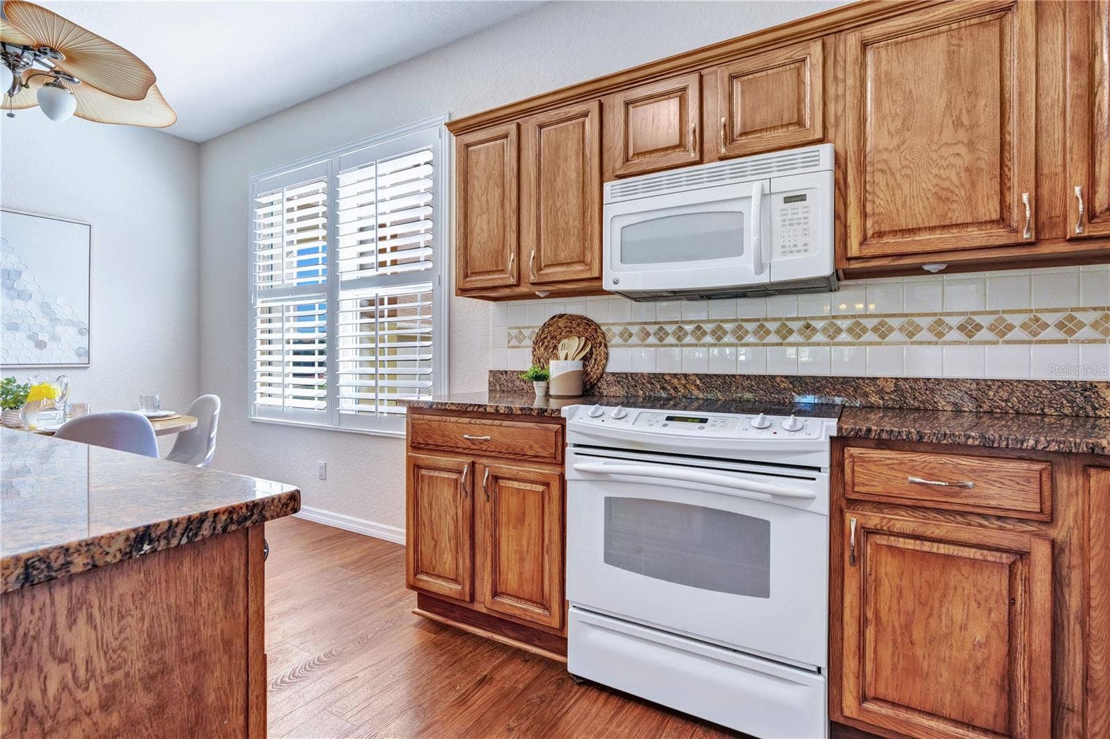 Spacious kitchen featuring warm wood cabinetry, generous counter space, and convenient access to the breakfast nook.