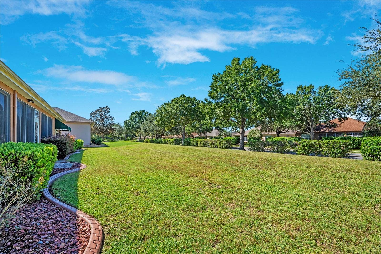 Beautiful open lawn and landscaped grounds complement this desirable single-story Florida home.