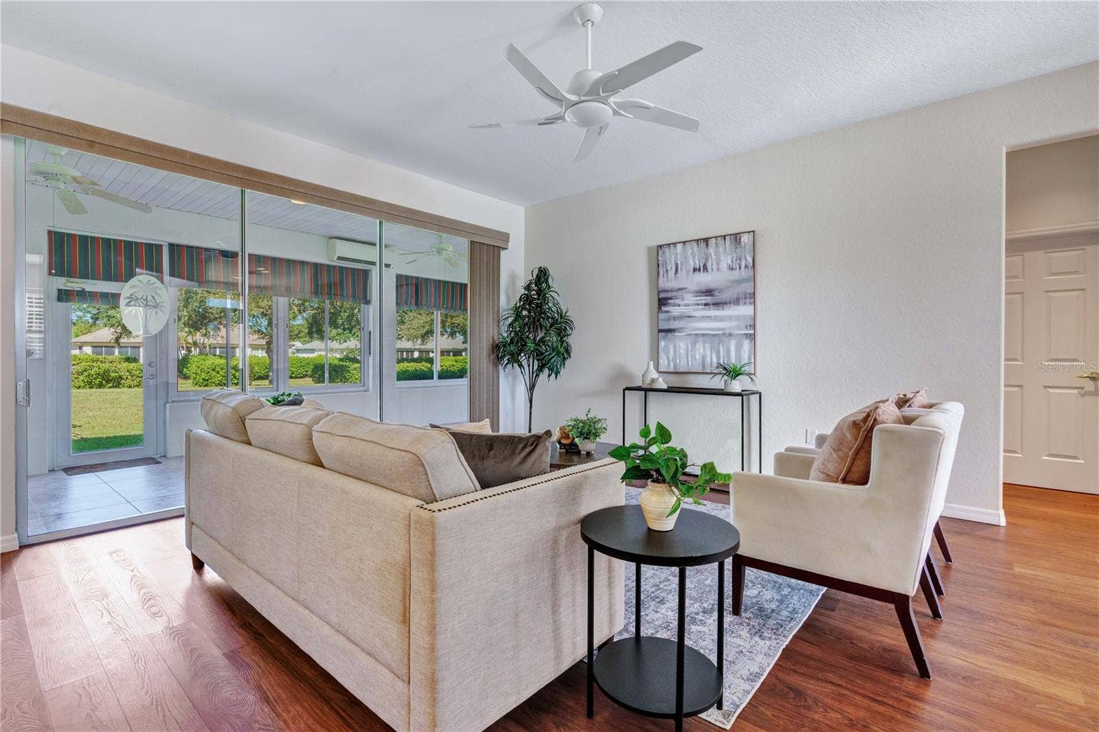 Welcoming living area with abundant windows and views toward the enclosed lanai