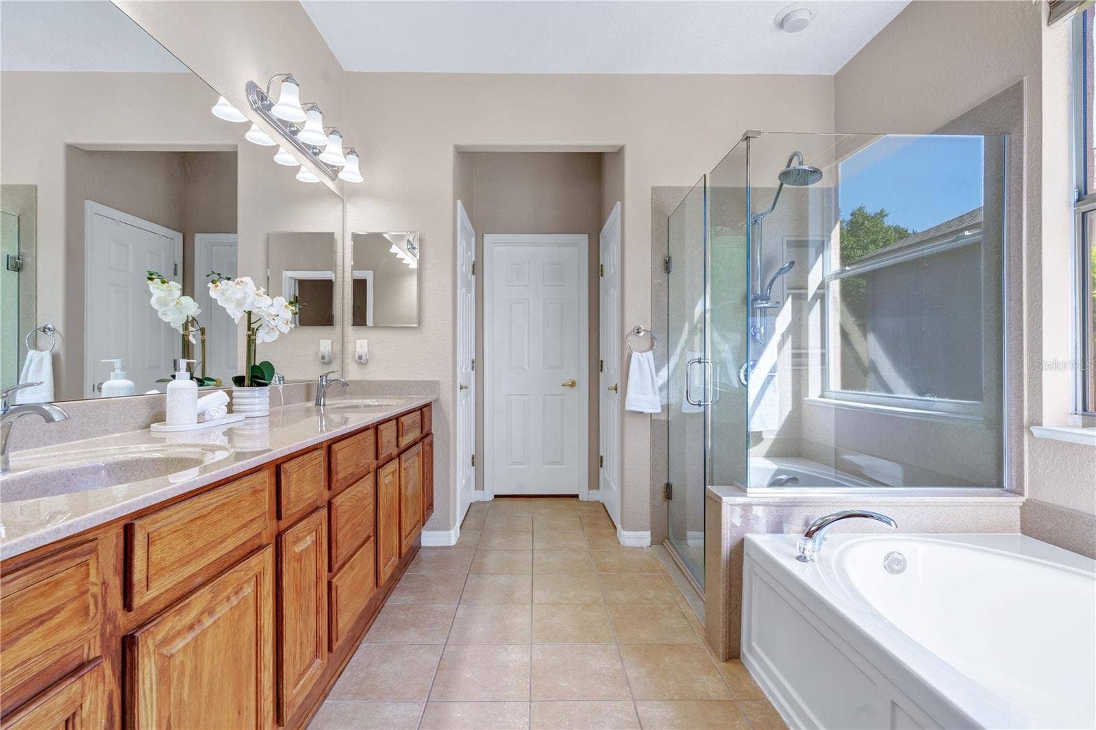 Enjoy a spacious primary bathroom designed for comfort, featuring an extended double vanity and separate bathing areas.