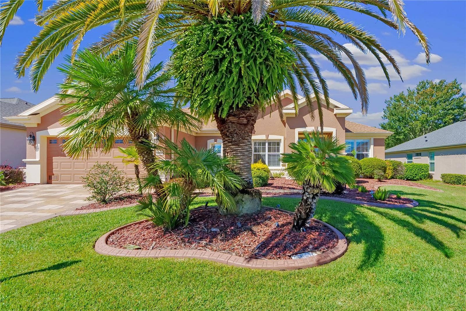 Lush palm trees and manicured landscaping enhance this home's inviting Florida curb appeal.