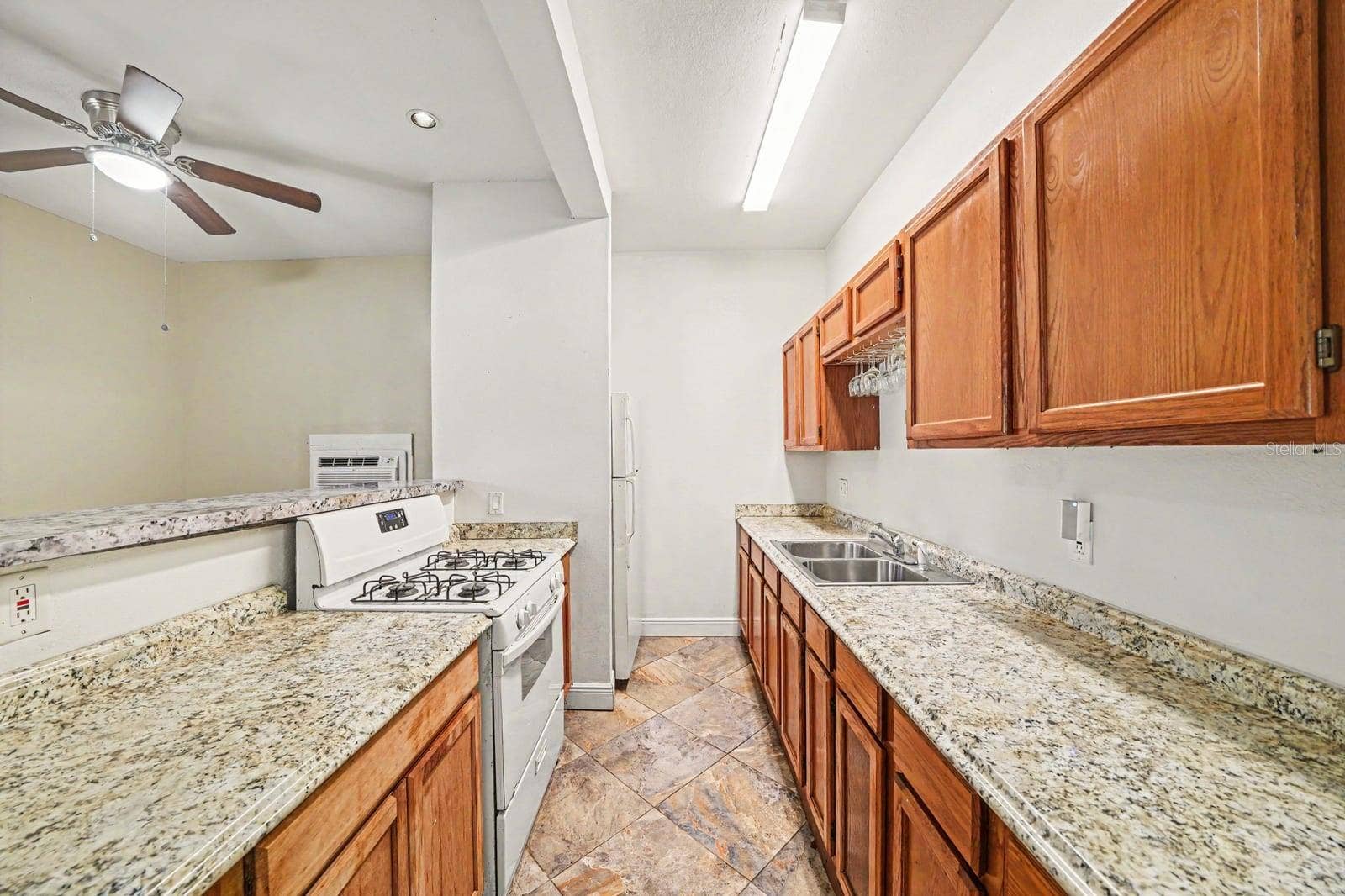 1015 S PENINSULA DRIVE, #1,2, Daytona Beach, FL 32118 Galley Kitchen with Wood Cabinetry, Granite Counters & Stainless Steel Appliances