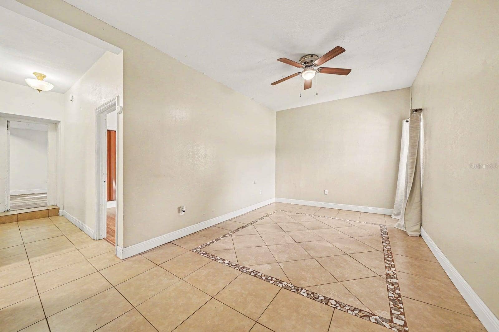 1015 S PENINSULA DRIVE, #1,2, Daytona Beach, FL 32118 Spacious Living Room with Ceiling Fan, Tile Flooring & Multiple Entry Points