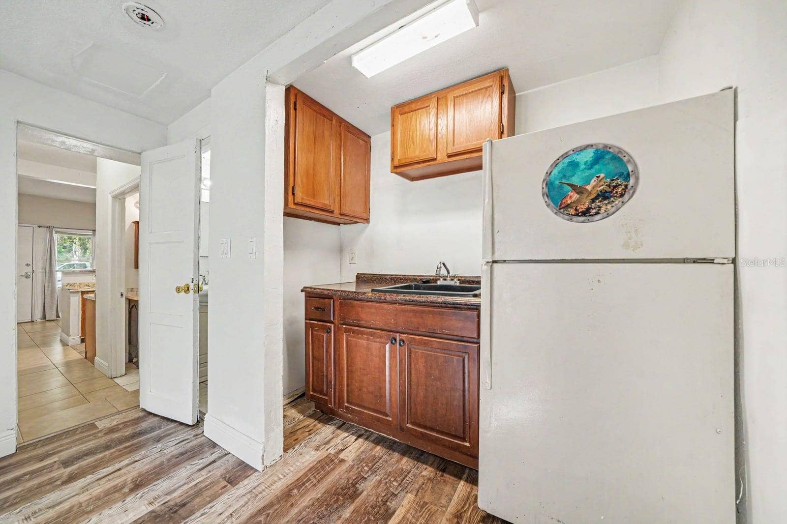 1015 S PENINSULA DRIVE, #1,2, Daytona Beach, FL 32118 Compact Kitchen with Wood Cabinets, Sink & Access to Main Living Area