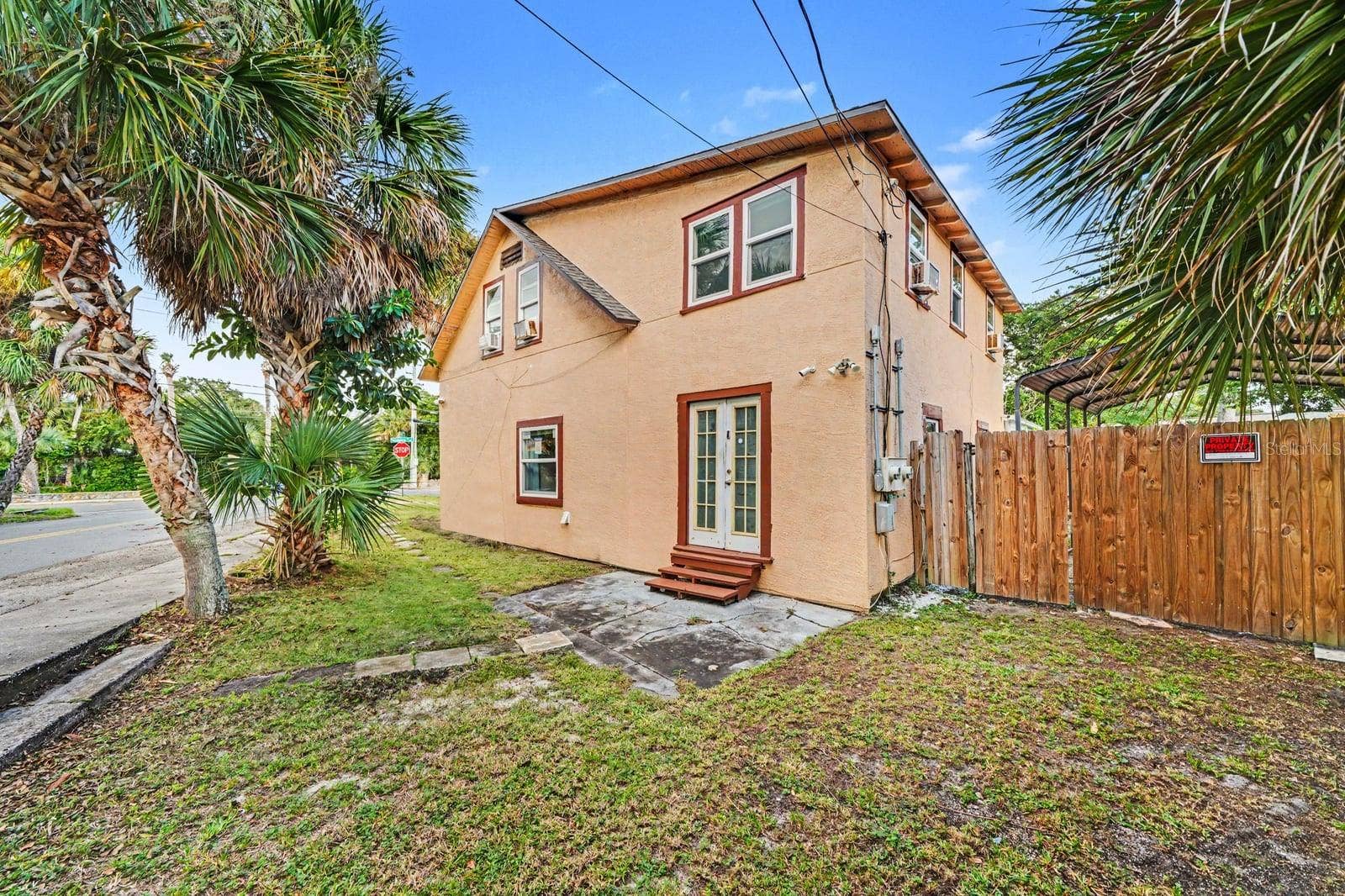 1015 S PENINSULA DRIVE, #1,2, Daytona Beach, FL 32118 Front Exterior with Palm Trees, Landscaping & Wooden Fence Gate