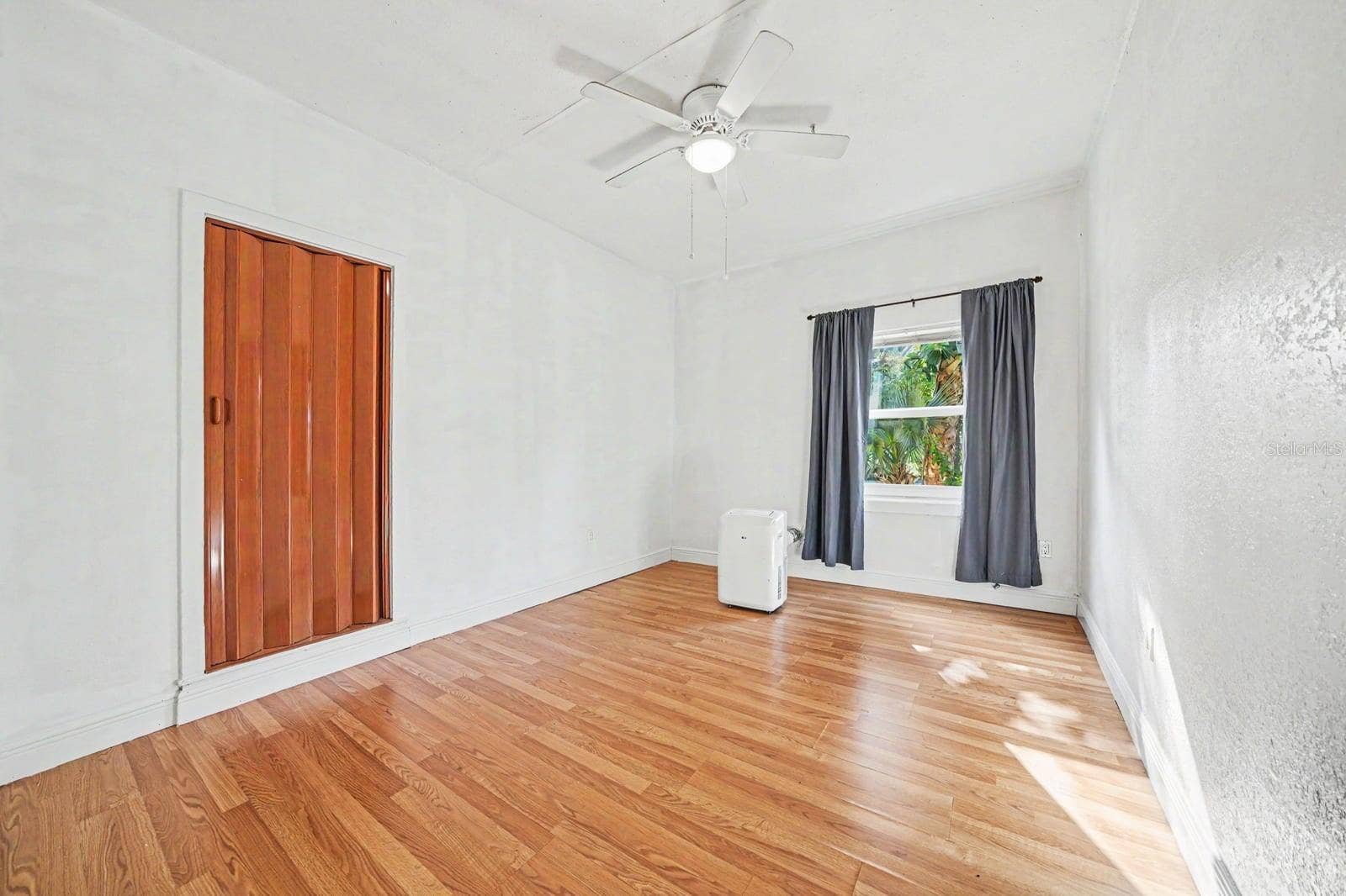 1015 S PENINSULA DRIVE, #1,2, Daytona Beach, FL 32118 Bedroom with Hardwood Floors, Ceiling Fan & Window with Landscape Views