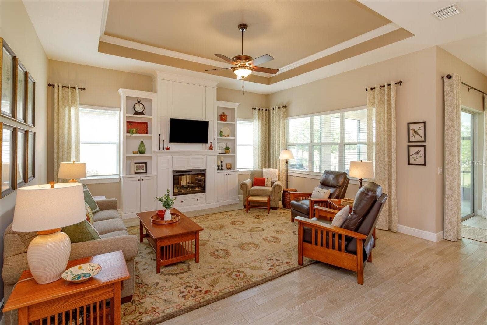 5663 SW 92ND AVENUE ROAD, Ocala, FL 34481 Living Room with Custom Built-in Cabinetry and Electric Fireplace. Designed with hidden storage on both sides of the fireplace and above the TV