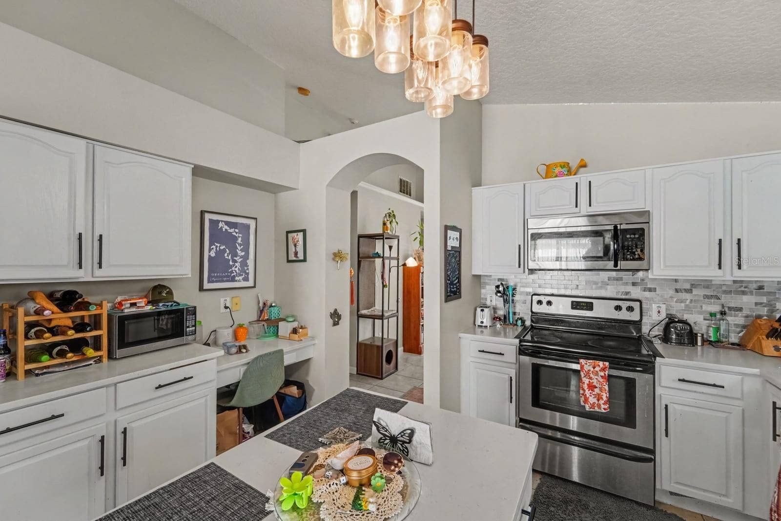 10913 BUCKWATER COURT, Orlando, FL 32817 Chef's Kitchen with White Cabinetry, Stainless Steel Appliances & Island Workspace