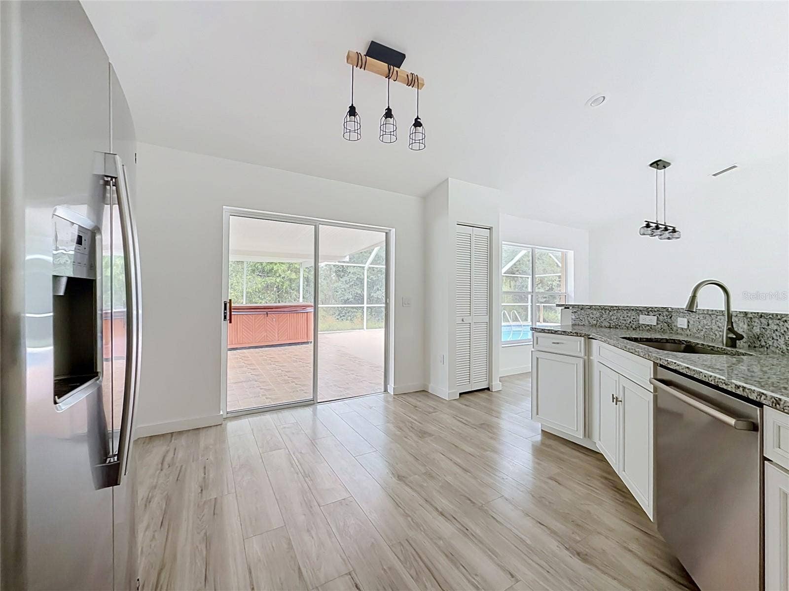 11 CARNATION COURT E, Homosassa, FL 34446 Sliding doors connect the kitchen to poolside living.