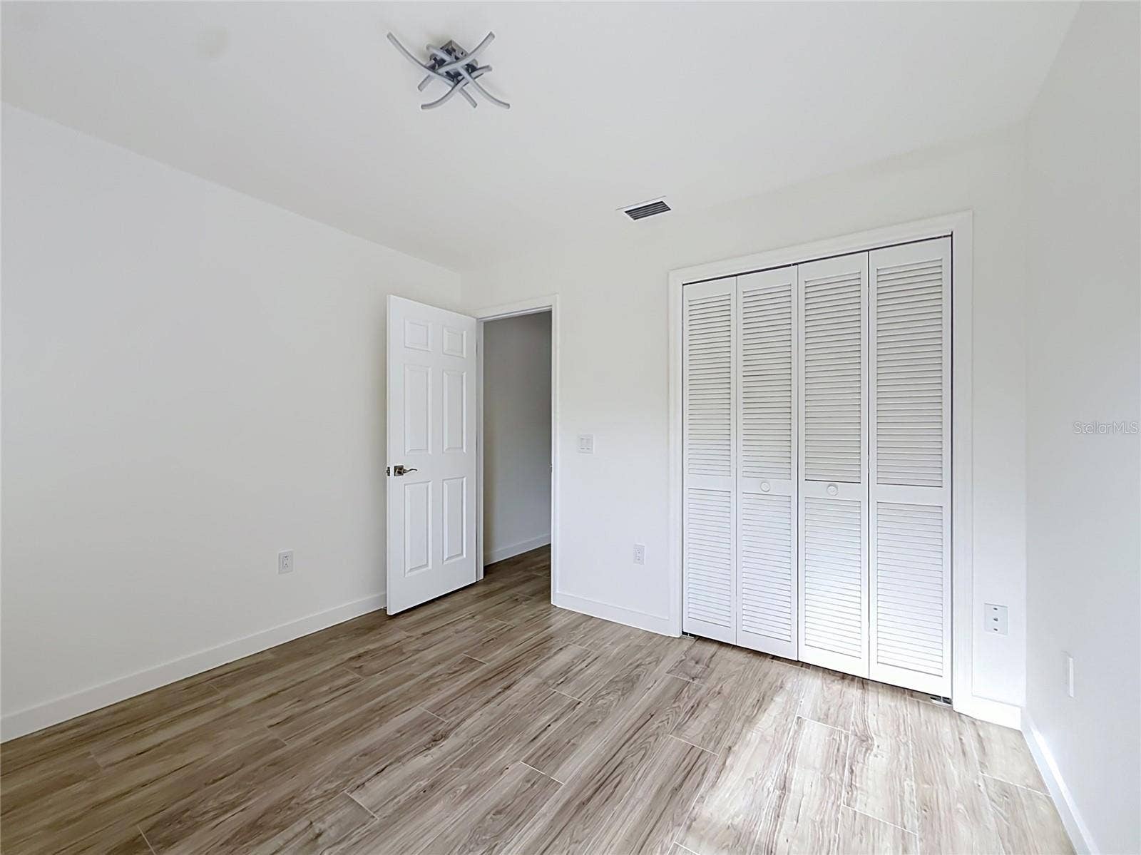 11 CARNATION COURT E, Homosassa, FL 34446 Wood-look flooring creates a warm, inviting bedroom.