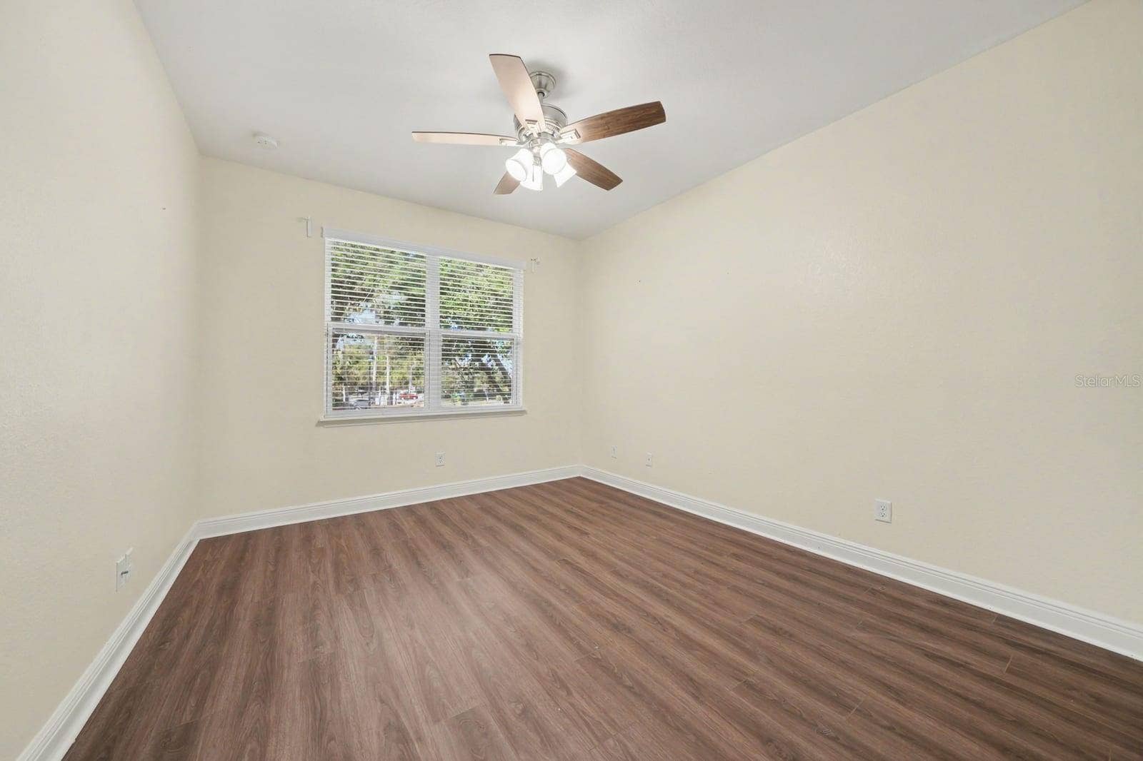 Spacious Bedroom with Hardwood Floors, Ceiling Fan & Natural Light
