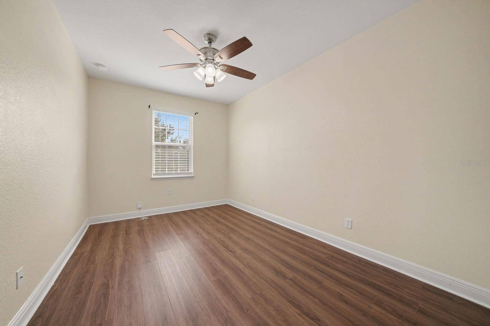 Comfortable Bedroom with Hardwood Floors, Ceiling Fan & Window View