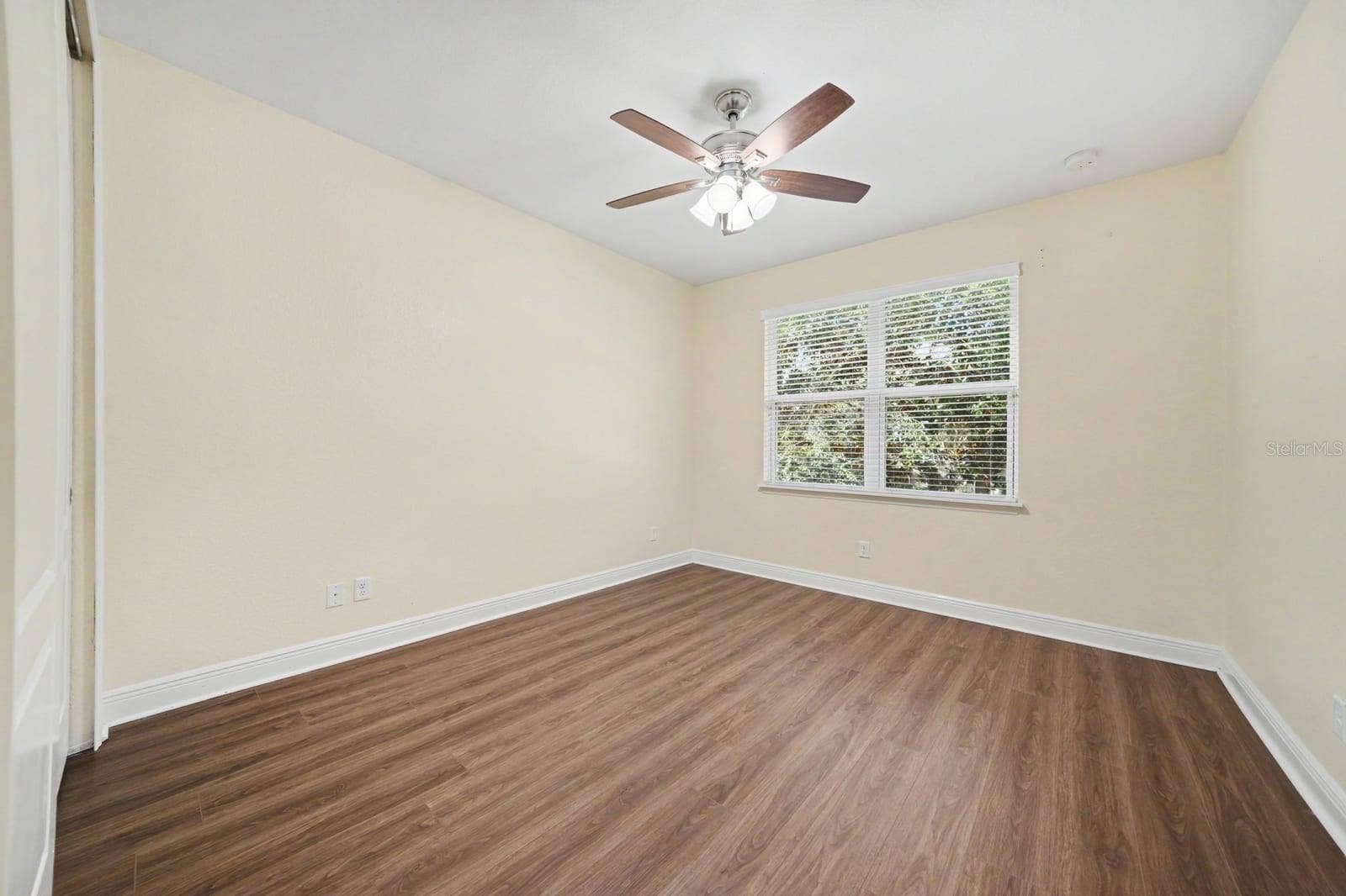 Secondary Bedroom Features Wood Flooring, Ceiling Fan & Bright Windows